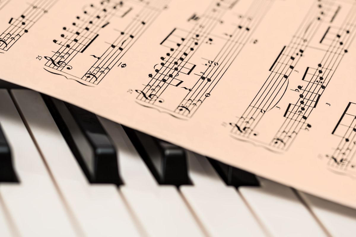 Sheet music resting on piano keys, representing reading and studying music