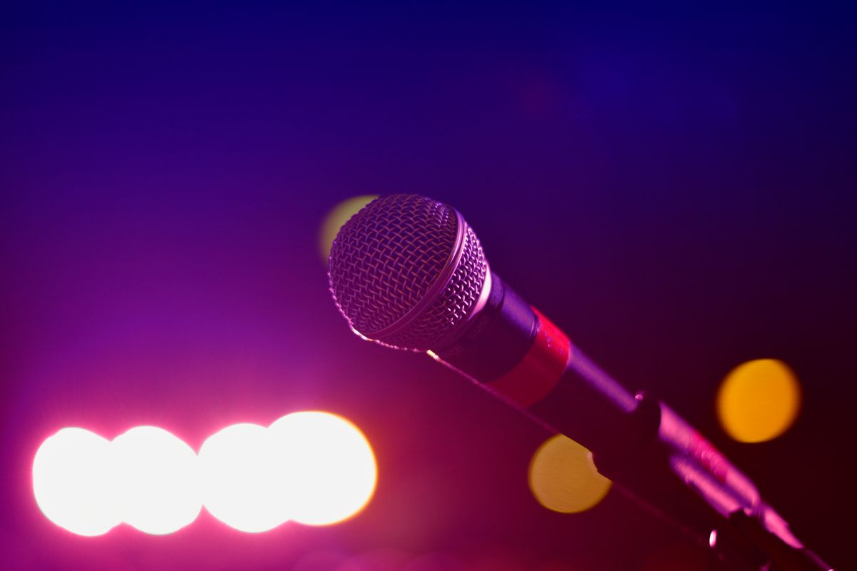 Stage microphone lit by pink and purple concert lighting